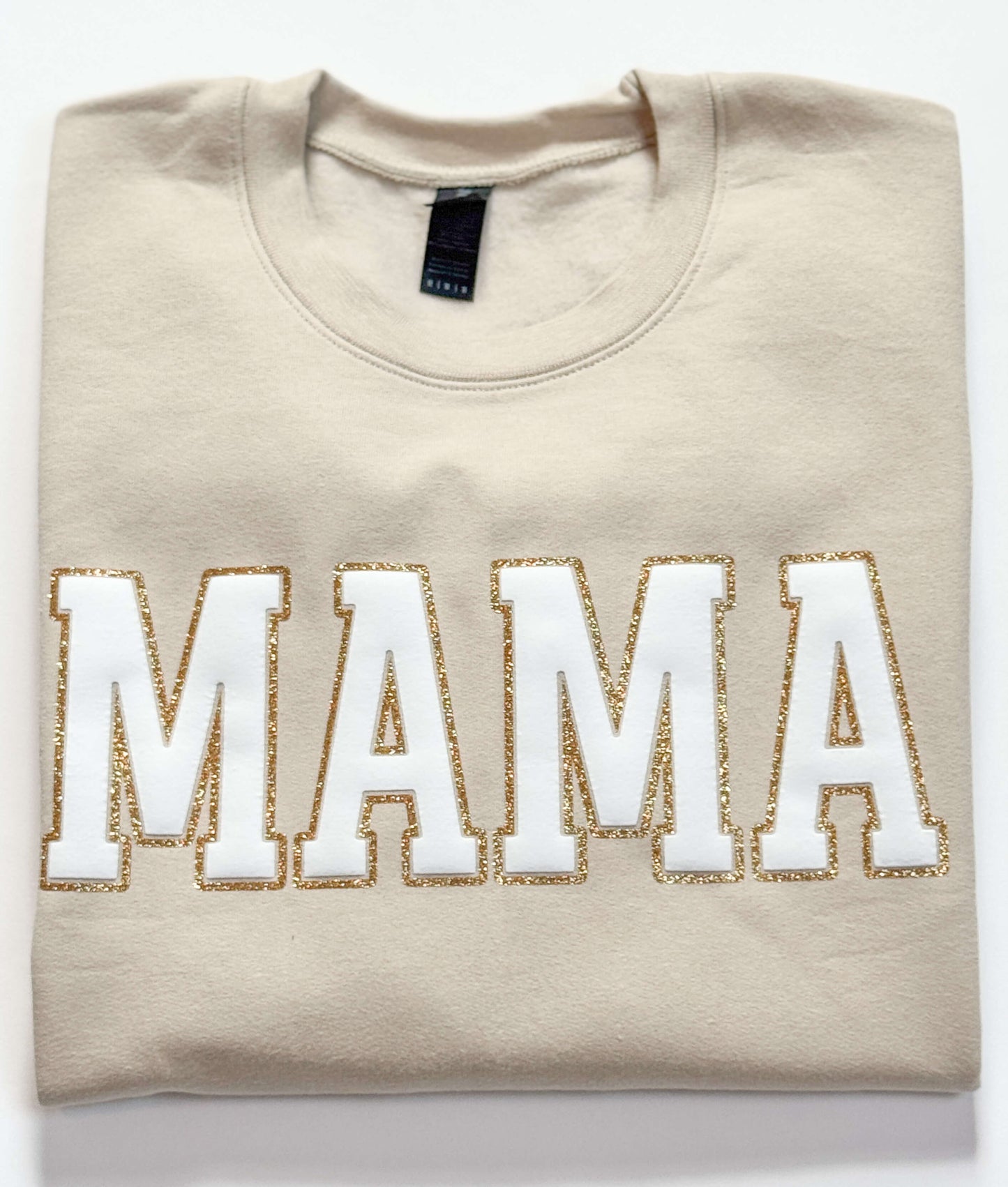 Gildan Softstyle Sweatshirt in Sand with a MAMA design in White Puff and outlined with gold glitter HTV for a 3D effect.