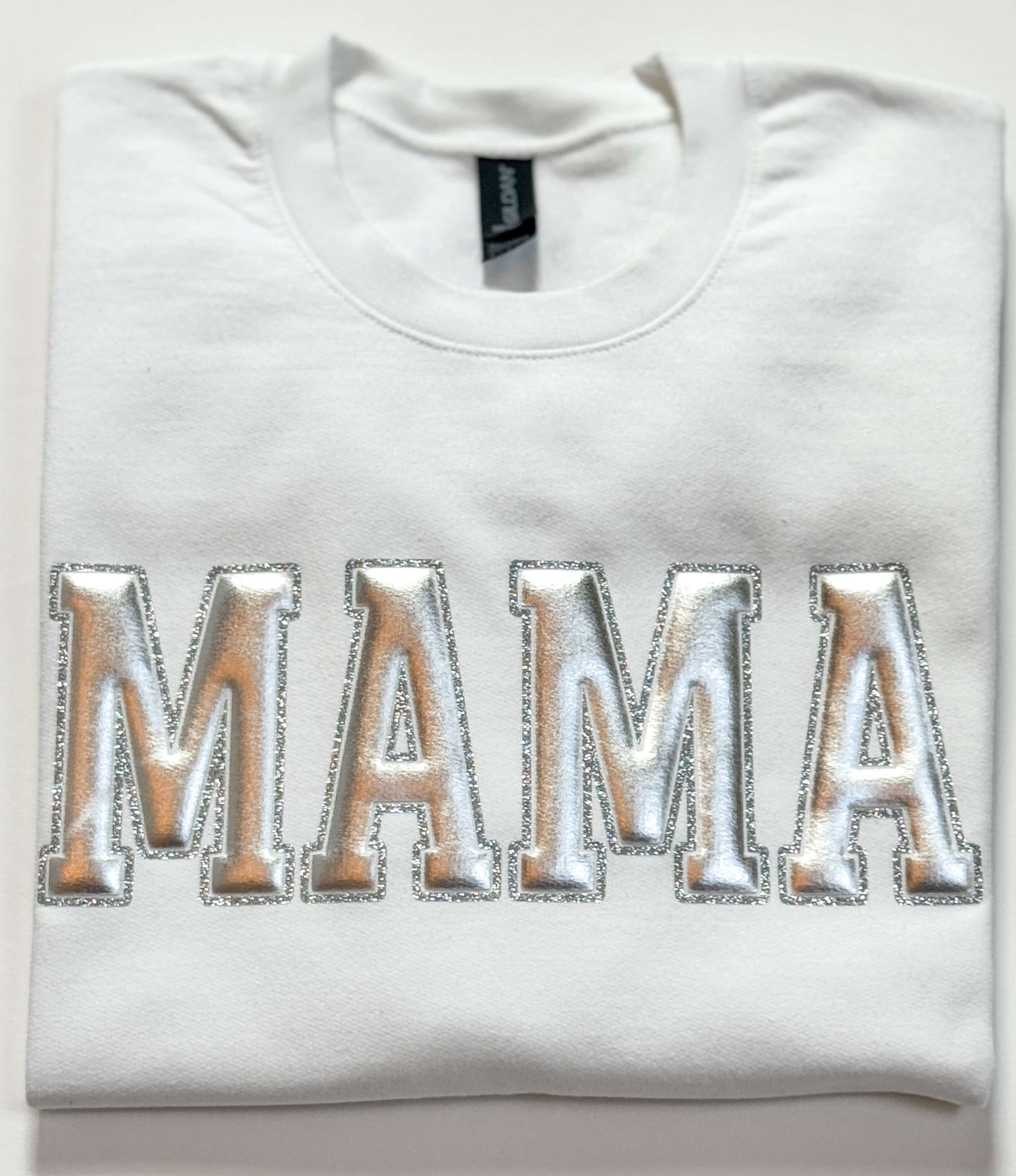 Gildan Softstyle Sweatshirt in White with a MAMA design in Silver Metallic Puff and outlined with silver glitter HTV for a 3D effect.