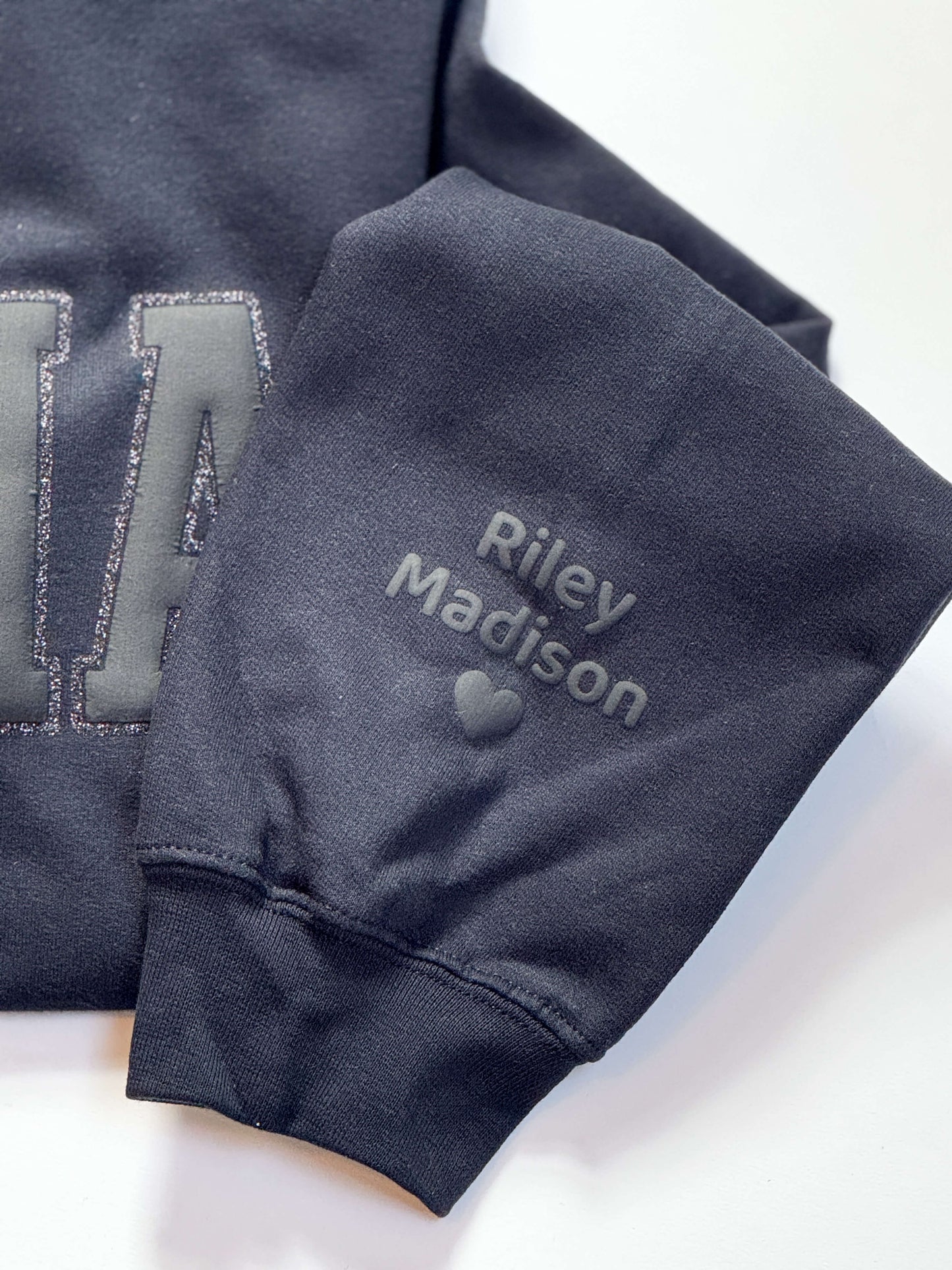 Gildan Softstyle Sweatshirt in Black with a MAMA design in Black Puff and outlined with black glitter HTV for a tone-on-tone look and 3D effect. Kid's names on sleeve in Puff HTV.