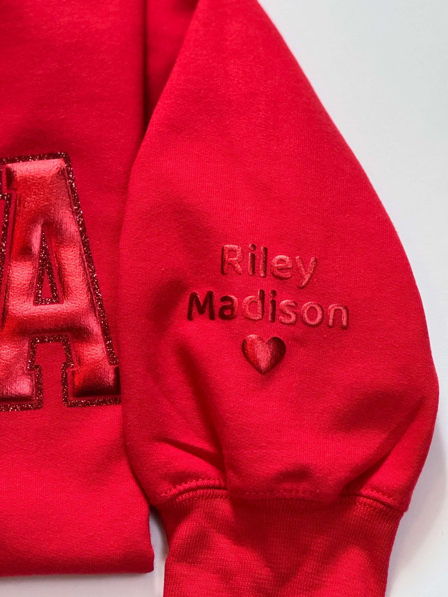 Gildan Softstyle Sweatshirt in Red with a MAMA design in Red Metallic Puff and outlined with red glitter HTV for a tone-on-tone look and 3D effect. Kid's names on sleeve in Red Metallic Puff HTV.