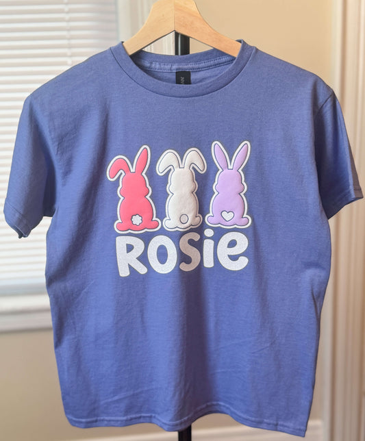 Gildan Youth Violet Easter T-Shirt with three bunnies in 3D Puff HTV - each in a different color outlined in glitter HTV which can be personalized with your child's name.