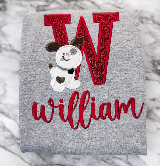Gildan Tshirt in the color sports gray with a cute valentine personalized design.  The design consists of your child's first initial in a red glitter HTV with red stitching.  A cute adorable puppy stands in front of the letter.  You can then embroider your child's name on the bottom in the color red.  Font used will be based on the length of the name, but we will try to match the listing as much as possible.  Any changes to the font will require your prior approval.
