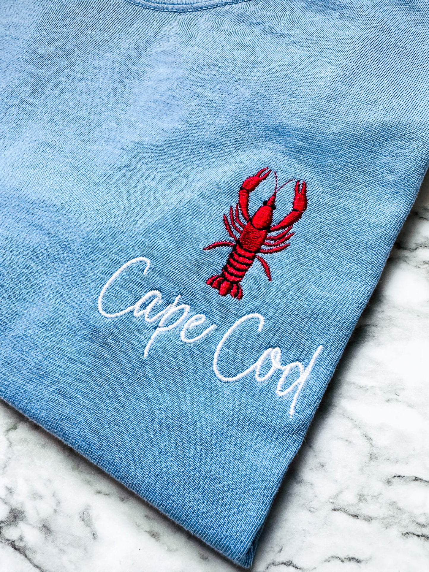 Close-up of the embroidered lobster on a Comfort Colors t-shirt, showcasing premium embroidery detail and personalized with the words Cape Cod.