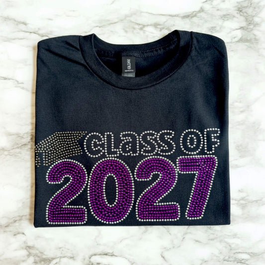 Class of 2027 rhinestone shirt with Electric Purple and Crystal lettering and graduation cap in black diamond rhinestones.  Design is offered on either a Bella Canvas or Gildan Softstyle black T-shirt.