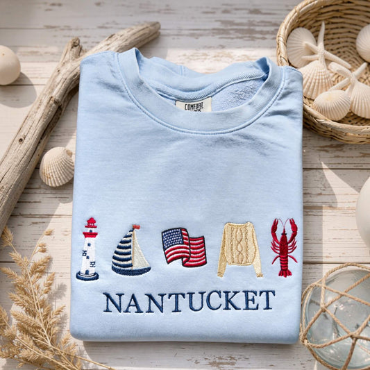 Comfort Colors personalized lightweight sweatshirt styled in a beach-inspired flat lay with embroidered coastal design and custom location.