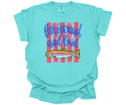 Hand-drawn trout fish graphic with hot pink horizontal lines and script text saying: "Fish Around and Find Trout" on a premium Comfort Colors T-shirt in the color Lagoon.