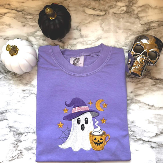 Comfort Colors T-Shirt in the color Violet with an embroidered ghost with a cute witch hat and a Halloween themed cup of coffee surrounded by stars and the moon.