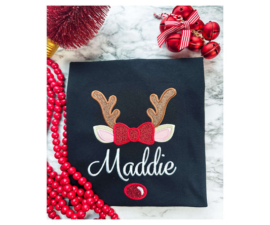 Family Christmas Matching Black Shirts showcasing an embroidered cute girl face reindeer design.  Each shirt can be personalized with your name.  Perfect for photos or Christmas morning.