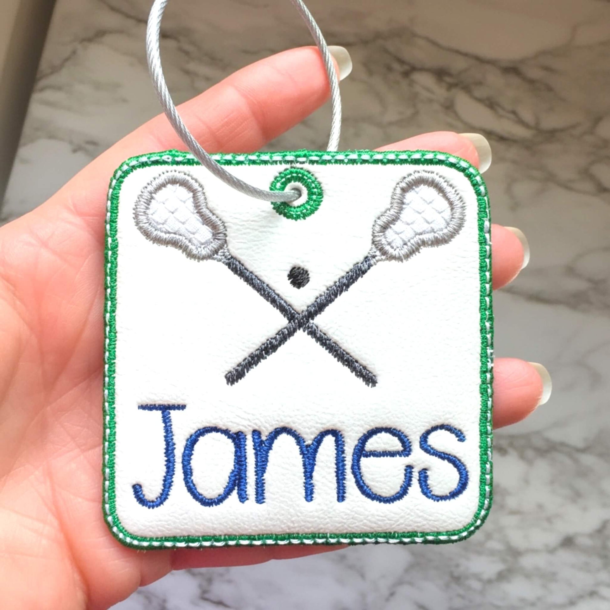 Personalized embroidered lacrosse bag tag with crossed lacrosse sticks and ball.  Add child's name in thread color of your choice.