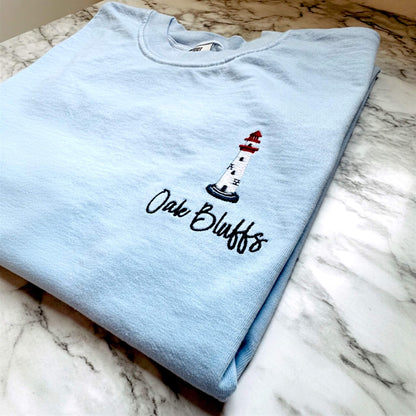 Close-up of the embroidered lighthouse on a Comfort Colors t-shirt, showcasing premium embroidery detail and personalized with Oak Bluffs.
