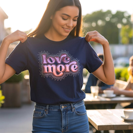 Your choice of a Bella Canvas or Gildan Softstyle Navy T-Shirt with a Love More design that is made up of Puff HTV (which gives it a 3D look) in a rose pink color that is outlined in rose gold glitter. There is a splatter of Crystal AB rhinestones surrounding the entire design.