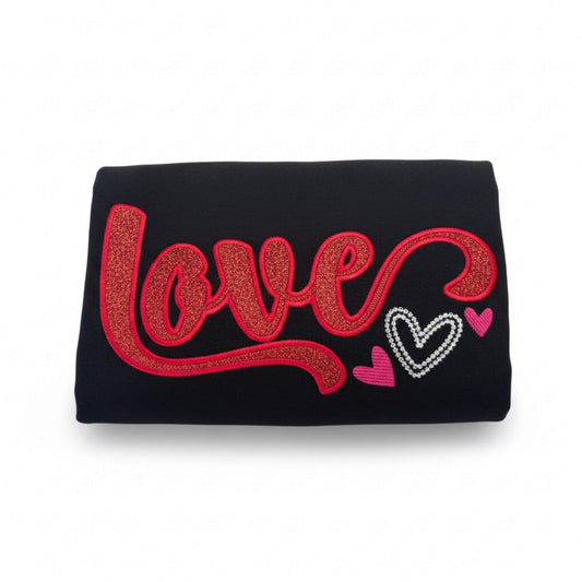 Gildan Black T-Shirt with the word "Love" in a script font embroidered in two different color options with glyphs added to some of the letters.  This shirt uses red glitter HTV with matching red stitching around the border of the word.  It also has small hearts in white and pink as accents to the side of the word.