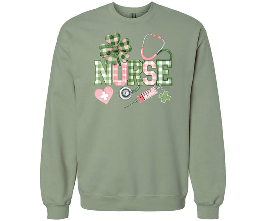Gildan Softstyle sweatshirt in the color Sage featuring a plaid “NURSE” design with shamrock, stethoscope, and other medical accents.