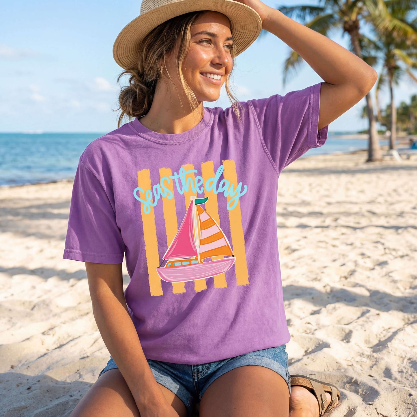 Model wearing a Comfort Colors Tee in the color Neon Violet with an inspirational "Seas the Day" graphic design on it that has a hand-drawn sailboat on yellow horizontal stripes.