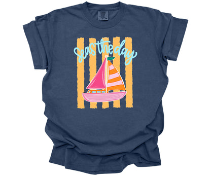 Inspirational "Seas the Day" graphic design with a hand-drawn sailboat on yellow horizontal stripes on a Comfort Colors Tee in the color China Blue.