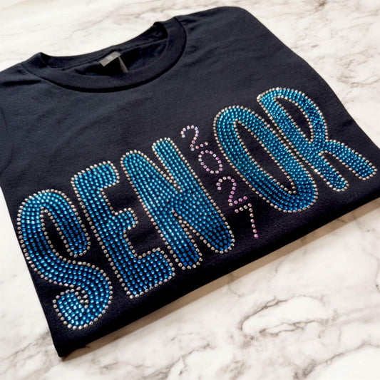 Senior 2027 rhinestone shirt in the color black with Capri, Chrome and Crystal AB rhinestones.  Design can be put on a Bella Canvas or Gildan Softstyle T-Shirt.