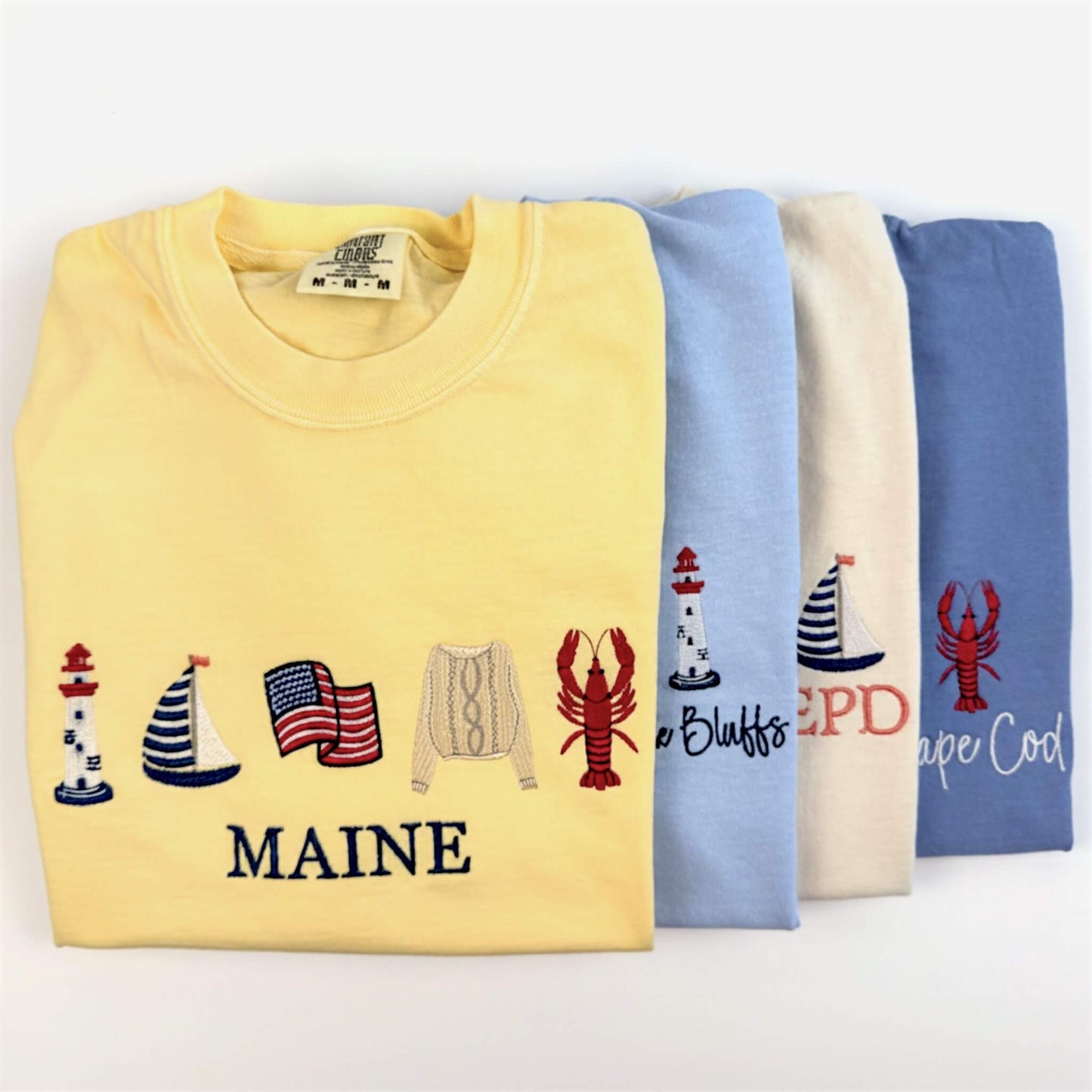 Full Coastal Collection of embroidered Comfort Colors tees featuring timeless seaside designs inspired by coastal living.  Part of the Coastal Collection.